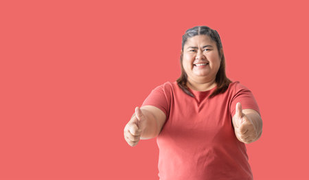 Asian fat woman, Fat girl , Chubby, showing hand thumbs up, isolated on pink background. Clipping paths for design work empty free spaceの写真素材