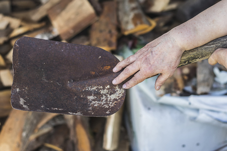 The old man's hand with a shovelの写真素材