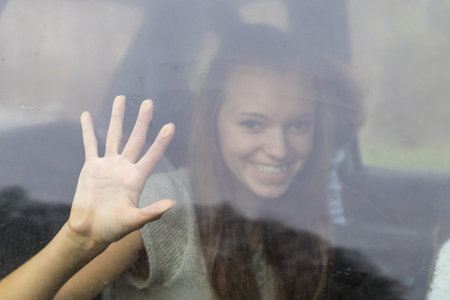 a pretty girl behind a wet windowの写真素材