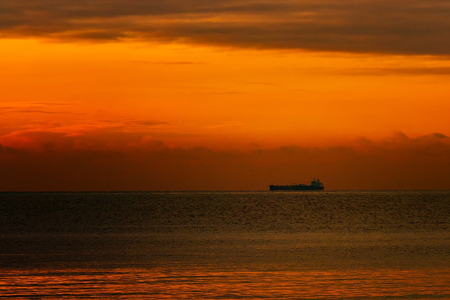 red sun sinking into the sea and on the coast.の写真素材