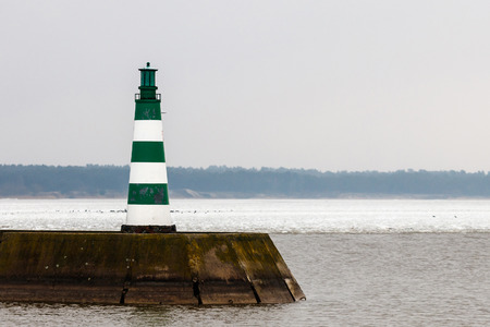 on a cold winter day, a colorful beacon appears at seaの写真素材