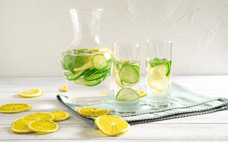 Light and fresh cucumber, lemon beverage on white table with lemon slices Drink for weight loss and lower blood pressureの写真素材