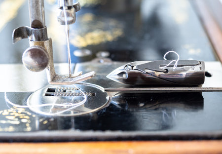 Presser foot and a bobbin of antique manual sewing machine, close up, side view, selected focus.の写真素材