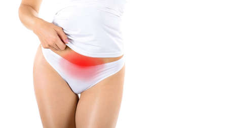 Premenstrual syndrome. Female faceless body in white underwear with red highlight in the lower abdomen, bikini line, isolated on white.の写真素材