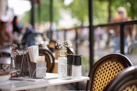 A table in a summer cafe partially served and a part of a street as background, selective focus.の写真素材