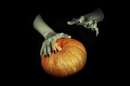 Witches hands with big Halloween in the dark, low key, selected focus. Samhain, magic, symbol, witchcraft, spell, pagan, ritual, divination, culture, religion concept.の写真素材