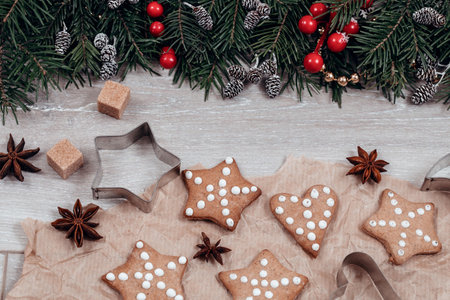 Christmas food flat lay. Tradition gingerbreads, cookie cutters, anise stars on baking paper and...