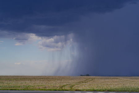 Storm front with rain and blue sky.の写真素材