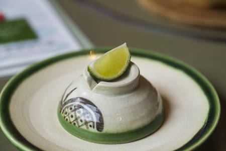 Lime slice and cut in to small pieces, places on a white ceramic plate and with salt for dipping. With vodka in a shot glass.の写真素材