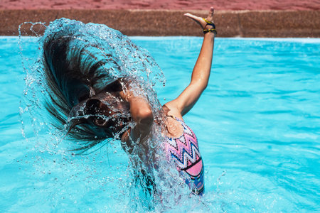 Motion freeze on a girl splashing the sea water with her hair