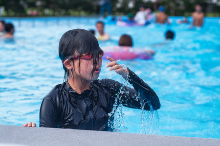 Beautiful little girl swims in the pool , cute little girl in pool in sunny day.little girl .