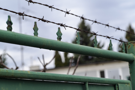 Barbed wire on the fence.Metal fence with barbed wire, guarded object.の写真素材