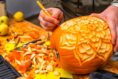Men's hands carve patterns on a pumpkin.Halloween preparation.