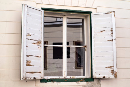 Row of ancient white weathered window shutters.Window with white wooden old shutters.