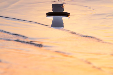 White coffee cup on beach with warm sunlight. Selective focus.Coffee cup on the sea sand on the...