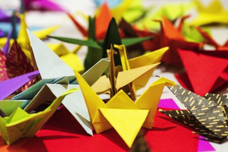 Multi-colored origami in the form of cranes on the table. Origami symbol.Color paper cranes of origami from paper.の写真素材