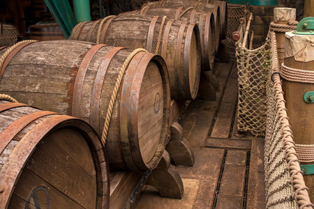 Old large wine wooden barrels on a wooden floor tied with a large rope.