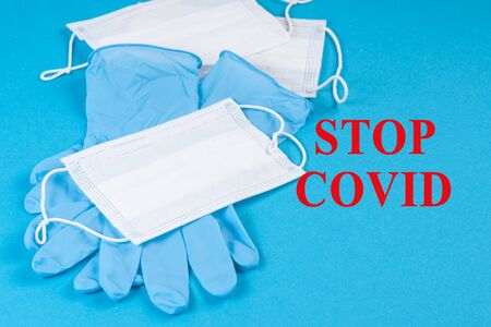 Medical blue gloves with white respiratory masks on a blue background with text.Healthcare and coronavirus, quarantine and deficiency of personal protection. Protection against a virus. Coronavirus.の写真素材