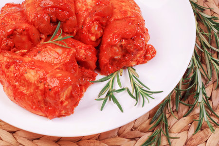 Raw marinated chicken thighs for grill and bbq.Cooking Chicken.Uncooked marinated chicken legs and marinade ingredients on the kitchen board.の写真素材