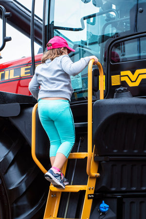 Presentation of new red tractors.New tractor at the exhibition.Children visiting the new tractor at...