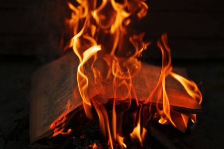 Concept for the destruction of confidential documents.Burning book on fire at night. People don't like reading. Books on fire. Burning news. Burned thoughts of books.の写真素材