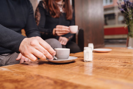 A girl and a man in a cafe drink coffee with milk. Coffee house.の写真素材