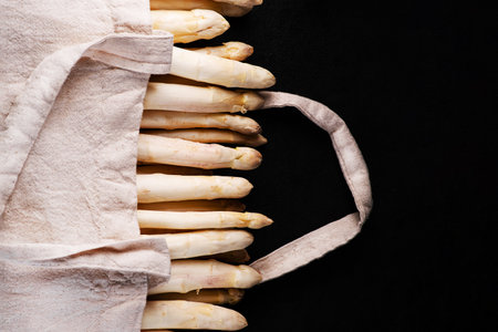 Super food.Healthy vegetables.Organic White organic asparagus in a fabric bag on a black background.Organic White Asparagus.Diet food.の写真素材