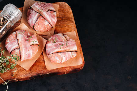 Grilled hamburgers.Copy space.Raw chicken burger on a wooden kitchen board with a rosemary branch and spices. Instant meat.の写真素材