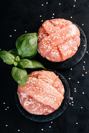 Grilled hamburgers.Copy space.Raw chicken burger with rosemary branch and spices. Instant meat.の写真素材