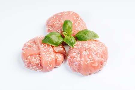 Grilled hamburgers.Raw chicken burger with basil leaves and spices on a white background. Instant meat.の写真素材