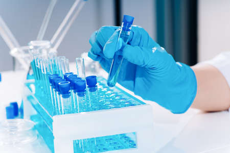 Development of new vaccines.hand of scientist holding flask with lab glasware and test tubes in chemical laboratory background, science laboratory research and development concept.laboratory equipment.Coronavirus pandemic stop. Medicine conceptの写真素材