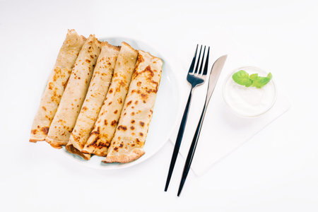 Pancakes on a white plate with cutlery. Pancake dessert.Crepes with chocolate cream.