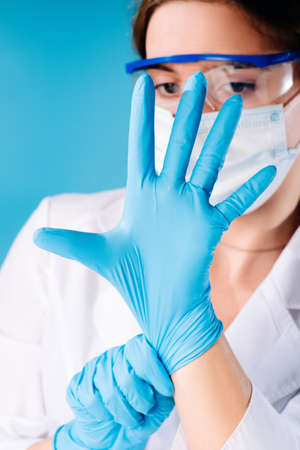 Girl medical worker dresses blue rubber gloves.Hands in protective gloves.の写真素材