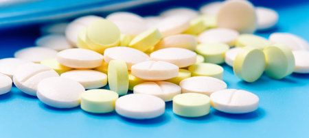 Pills close-up white and yellow color on a blue background. Medical devices. Close-up of pills.
