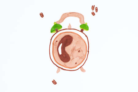 Child's drawing alarm clock with coffee inside and grains on a white background isolate. Creative modern still life photography concept.Alarm clock as coffee cup.の写真素材