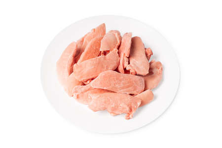 Raw frozen chicken thigh meat on a white plate on a white isolated background. Isolade.Close up, space for text, copyspaceの写真素材