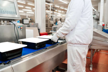 modern poultry processing plant.Meat processing in food industry.Packing of meat slices in boxes on a conveyor belt.Line for the production of semi-finished meat products.の写真素材