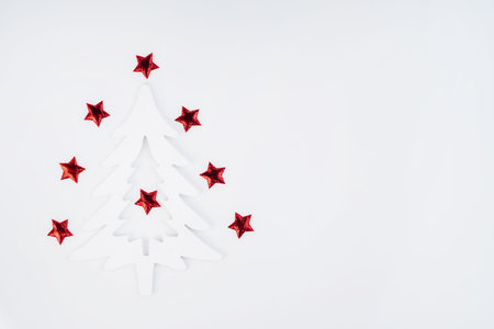 Simple minimalistic Christmas home decor - a close up view of a wooden Christmas tree, candles and a...
