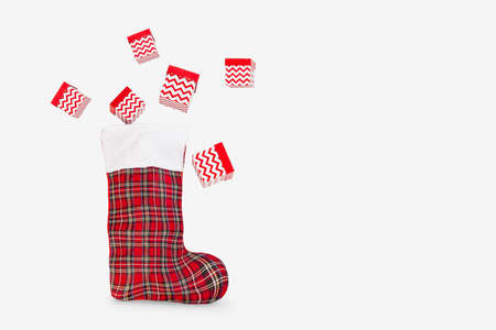 Santas Christmas boot with New Years gifts on a light background. Gifts fly out of Santas boot.の写真素材