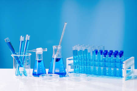 Collection of medical flasks on a blue background.Science glass flask blue chemistry laboratory banner background. Concept of medicineの写真素材