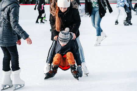 Soft,Selective focus.Mom with baby boy 6 years old, learn train, ride winter city rink, ice skating....