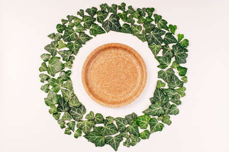 Eco concept. Copy space.Recycling,eco-friendly concept.Disposable eco cutlery, on a light background, for food delivery.Green leaves frame on white background with cutlery .の写真素材