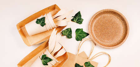 Craft paper bag for food delivery.Copy space.Eco craft paper tableware,cups,fast food containers.Recycling,eco-friendly concept.Disposable eco cutlery,plates,spoons,knives,forks on a light background.の写真素材