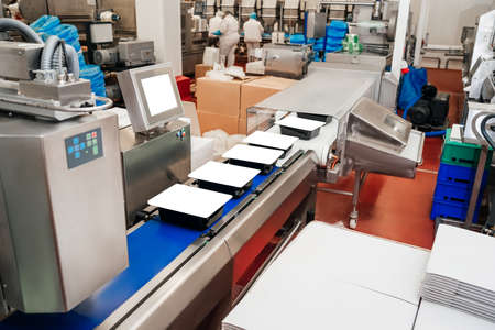 modern poultry processing plant.Meat processing in food industry.Packing of meat slices in boxes on a conveyor belt.Line for the production of semi-finished meat products.の写真素材