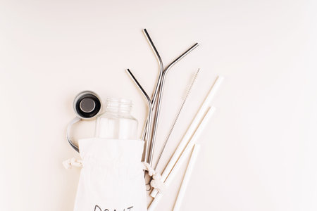 Cotton bag,glass bottle and metal reusable and paper disposable tubes.Copy space.Ecological,natural...