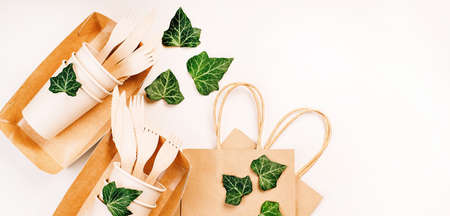 Eco craft paper tableware,cups,fast food containers.Recycling,eco-friendly concept.Disposable eco cutlery,plates,spoons,knives,forks on a light background.Craft paper bag for food delivery.Copy space.の写真素材
