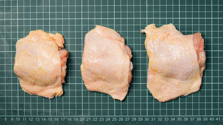 Chicken thigh meat on a linear board. Raw chicken thigh with skin, boneless, for cooking.の写真素材