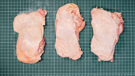 Chicken thigh meat on a linear board. Raw chicken thigh with skin, boneless, for cooking.の写真素材