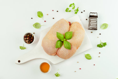 Chicken leg meat.Raw fresh chicken leg meat with skin on a light background with fresh herbs.Food for retail.Procurement for designers.Ogranic food,healthy eating.Food concept.Top view.の写真素材