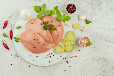 Raw fresh chicken fillet on a gray background with fresh herbs.Raw chicken meat.Copy space.Food for retail.Ogranic food,healthy eating.Food concept.Top view.Chicken breast Fillets.Close up.の写真素材